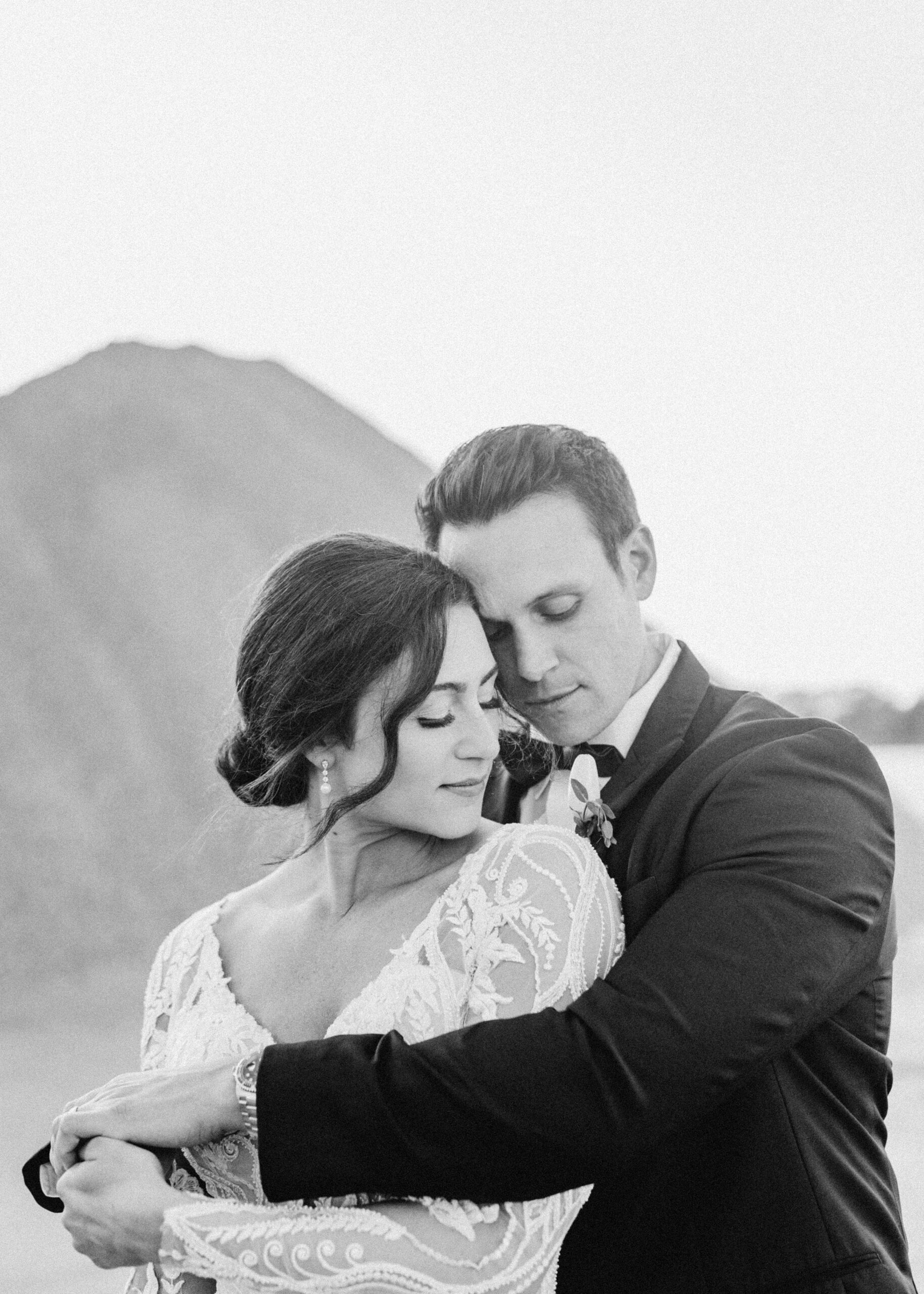 black and white photo of bride and groom forehead to forehead enjoying their quiet moment